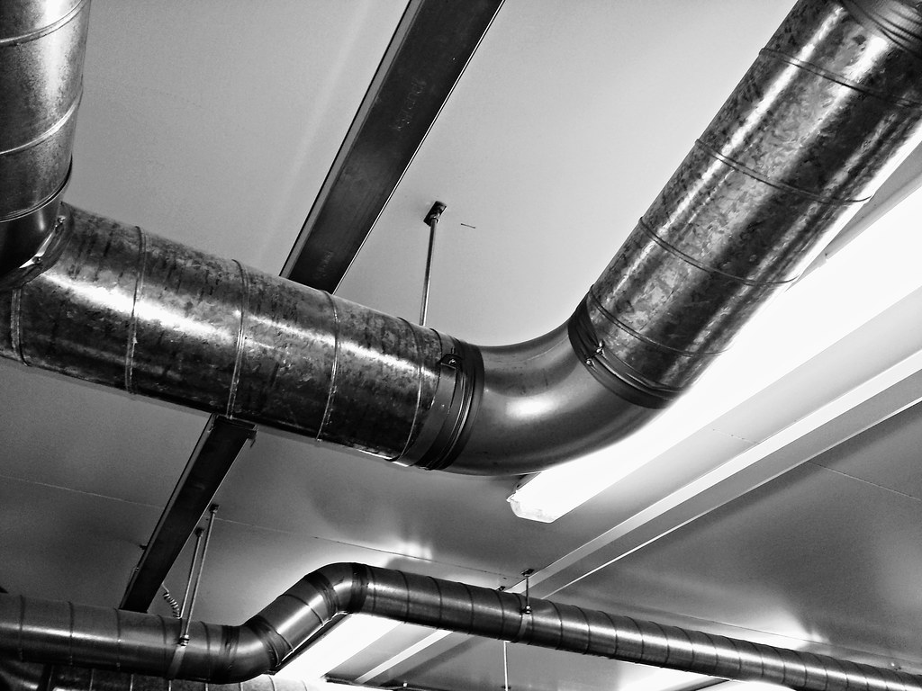 Réseau de gaines de ventilation métalliques au plafond d'un bâtiment